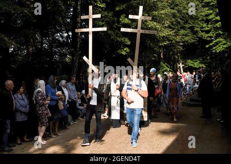 Gläubige gehen mit Kreuzen und religiösen Symbolen während der Prozession um die Kirche herum.jedes Jahr findet die Hauptfeier des orthodoxen Festes, die Verklärung Jesu Christi, auf dem Heiligen Berg von Grabarka statt. Über 10,000 Gläubige kamen in diesem Jahr zum Gebet auf den heiligen Berg. Stockfoto