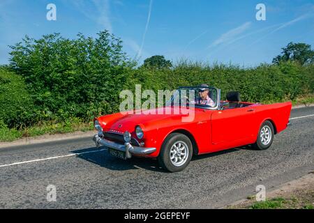 1963 60s Red Sunbeam Alpine Sport-Coupé 1582cc Cabrio mit zwei Sitzen auf dem Weg zur Capesthorne Hall Oldtimer-Ausstellung im Juli, Cheshire, Großbritannien Stockfoto