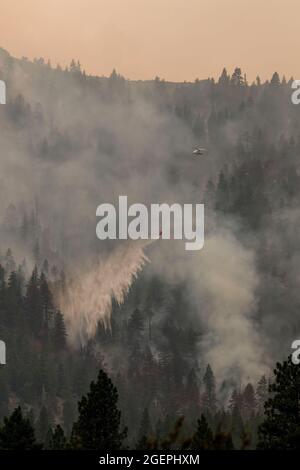 Milford, Usa. August 2021. Ein Hubschrauber wirft Wasser auf das Dixie-Feuer. Ein Stichprobenbrand aus dem Dixie-Feuer breitet sich auf den Highway 395 aus. CAL Fire berichtet, dass das Dixie Fire mittlerweile über 700,000 Acres gewachsen ist. Die Brandursache wird noch untersucht. Kredit: SOPA Images Limited/Alamy Live Nachrichten Stockfoto