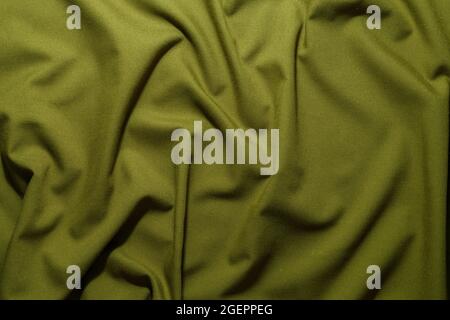 Zerknittertes, olivgrün zerknittertes, hellbraunes Khaki-Segeltuch – Hintergrund und Textur für das ganze Bild Stockfoto