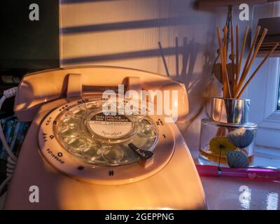 Ein altmodisches Telefon aus den 1980er Jahren, das am späten Nachmittag durch das Fenster strömte Stockfoto