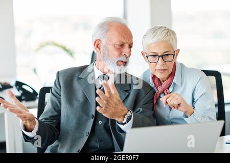 Geschäftsbüro Person Diskussion Laptop Problem besorgt Teamarbeit Senior Meeting Stockfoto