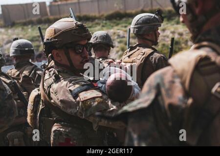 Kabul, Afghanistan. August 2021. Ein US-Soldat beruhigt ein Kleinkind während einer Evakuierung am Hamid Karzai International Airport, Kabul, Afghanistan, am 20. August 2021, In den Tagen nach dem Sturz von Kabul an die Taliban-Bewegung, inmitten von Chaos und Panik Szenen auf dem capitalâÂ € Â™s Flughafen. Foto von CENTCOM-Balkis Press/ABACAPRESS.COM Quelle: Abaca Press/Alamy Live News Stockfoto