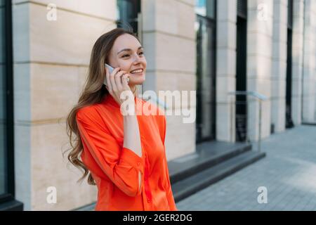 Die dreißigjährige Frau kommuniziert über ein Mobiltelefon in der Stadt Stockfoto