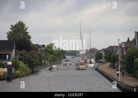 Segelboot mit festem langen Mast fuhr über die Stahlhubbrücke über die Gouwe in Boskoop in Südholland in den Niederlanden Stockfoto