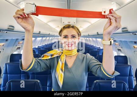 Fluggastgeberin, die vor dem Abflug eine Sicherheitsvorführung durchführt Stockfoto