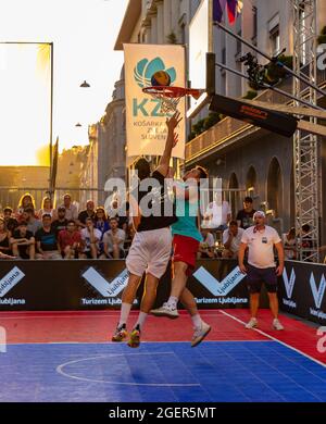 Ein Bild von zwei Mannschaften, die bei einem besonderen Event in Ljubljana 3x3 Basketball spielen. Stockfoto