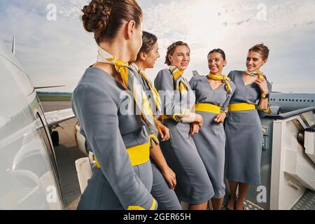 Gruppe von fünf Stewardessen, die draußen ein Gespräch führen Stockfoto