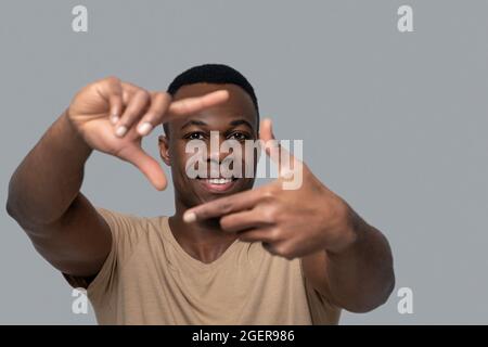 Dunkelhäutiger junger Mann, der mit seinen Händen Gesten macht Stockfoto