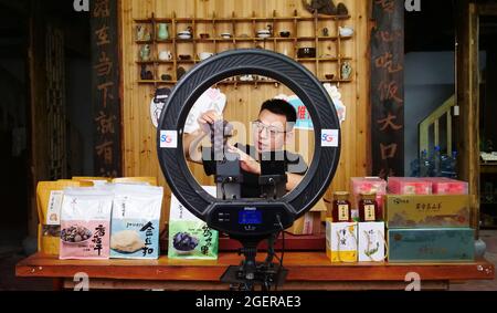 (210821) -- FUZHOU, 21. August 2021 (Xinhua) -- Chen Shangyou wirbt in seinem Livestreaming-Raum in der Gemeinde Xiadang in Ningde, südöstlich der Provinz Fujian, für Trauben, am 17. August 2021. Im Jahr 2020 kehrte Chen Shangyou, der in der E-Commerce-Branche tätig war, in die Gemeinde Xiadang zurück und richtete ein Livestreaming-Team ein, um lokale landwirtschaftliche Produkte wie Tee und Honig zu verkaufen. Im Jahr 2017 schlug China eine Strategie für die ländliche Belebung als Schlüsselmaßnahme zur Beschleunigung der Modernisierung der Landwirtschaft und der ländlichen Gebiete vor und hat seitdem eine Reihe von Maßnahmen zur Erstellung des Fahrplans für die ländliche Belebung verabschiedet. Stockfoto