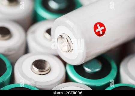 AA-Akkus mit einer weißen Batterie mit positiver Polarität. Selektiver Fokus Stockfoto