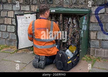 BT OpenReach-Ingenieur, der an einer offenen Versorgungsbox in Edinburgh, Schottland, Großbritannien, arbeitet. Stockfoto