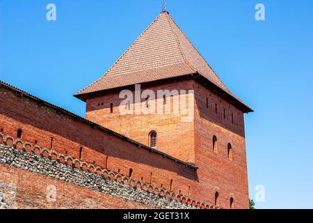 LIDA, WEISSRUSSLAND - 10. JULI 2021: Archäologisches Denkmal mittelalterlicher Stein und Ziegel Lida Burg, historischer Schauplatz für Touristen gegen den blauen Himmel in Stockfoto