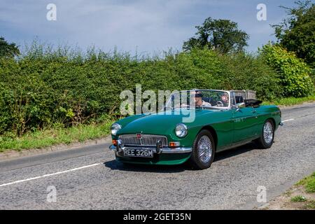 1974 70er Jahre grünes MG B MGB 1798cc Benzin 2dr Cabrio auf dem Weg zur Capesthorne Hall Classic Car Show im Juli, Ceshire, Großbritannien Stockfoto