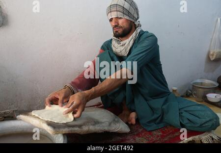 Kabul, Afghanistan. August 2021. Ein Mann arbeitet in einer Bäckerei in Kabul, der Hauptstadt Afghanistans, am 21. August 2021. Angesichts der politischen Unsicherheit und der Instabilität der Preise für Küchenartikel scheint die Normalität in die afghanische Hauptstadt Kabul zurückgekehrt zu sein. UM MIT „Feature: Normalität kehrt scheinbar inmitten politischer Unsicherheit nach Kabul zurück“ zu GEHEN. Quelle: Str/Xinhua/Alamy Live News Stockfoto