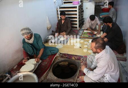 Kabul, Afghanistan. August 2021. Menschen arbeiten in einer Bäckerei in Kabul, der Hauptstadt Afghanistans, 21. August 2021. Angesichts der politischen Unsicherheit und der Instabilität der Preise für Küchenartikel scheint die Normalität in die afghanische Hauptstadt Kabul zurückgekehrt zu sein. UM MIT „Feature: Normalität kehrt scheinbar inmitten politischer Unsicherheit nach Kabul zurück“ zu GEHEN. Quelle: Str/Xinhua/Alamy Live News Stockfoto