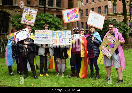 Manchester, Großbritannien, 21. August 2021. Eine kleine Demonstration im Zentrum von Manchester, Großbritannien. Zu den Forderungen gehörte die Beendigung der Kommerzialisierung des lokalen LGBT Pride. Dies folgt auf Proteste in den Medien über die Manchester Pride-Veranstaltung, bei der die Finanzierung einiger lokaler Gruppen beendet wird, darunter der George House Trust, der Dienstleistungen für Menschen mit HIV und von HIV betroffene Menschen und das Kondomverteilungsprogramm der LGBT-Stiftung anbietet. Protestgruppe junger Menschen mit Plakaten. Quelle: Terry Waller/Alamy Live News Stockfoto