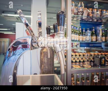 Der Barcounter mit Flaschen und Geräten zum Abfüllen von Bier. Vorrichtung zum Abgeben von Bier im Pub. Stockfoto