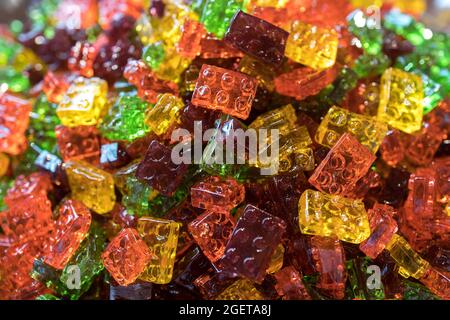 Süße Gummiknüppel, mehrfarbige Stäbchen in Form von lego auf einem Kirmes-Stand im Stapel Stockfoto