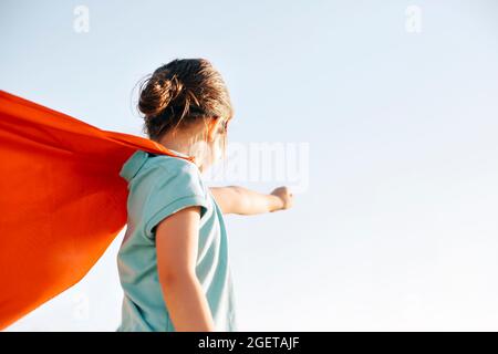 Porträt von Superhero Kind vor blauem Himmel Hintergrund. Freude und Kindheit Konzept Stockfoto