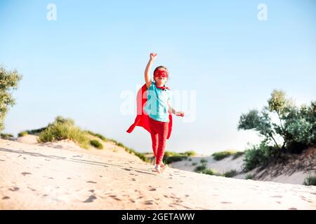 Porträt von Superhero Kind vor blauem Himmel Hintergrund. Freude und Kindheit Konzept Stockfoto