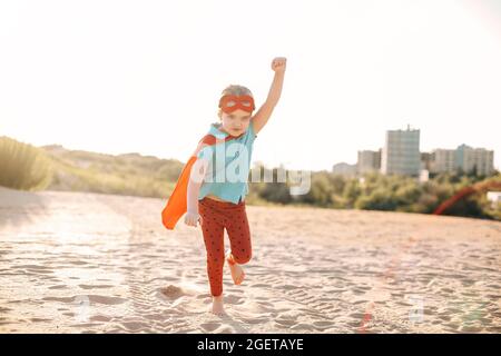 Porträt von Superhero Kind vor blauem Himmel Hintergrund. Freude und Kindheit Konzept Stockfoto