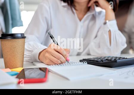 Cropped Frau, close-up weibliche Hände halten Stift Notizen machen arbeiten im Büro, Geschäftskonzept. Tisch Schreibtisch, Frau arbeiten, mit Smartphone, Kalkül Stockfoto
