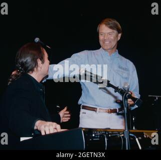 Glen Campbell und der Songwriter Jimmy Webb geben am 20. April 1996, zwei Tage vor seinem eigentlichen Geburtstag, eine improvisierte Performance bei Campbells Überraschungsfeier zum 60. Geburtstag in Branson, Missouri. Jimmy Webb schrieb und arbeitete mit Campbell an vielen seiner Hits zusammen, darunter „By The Time I Get To Phoenix“, „Wichita Lineman“ und „Galveston“. Stockfoto