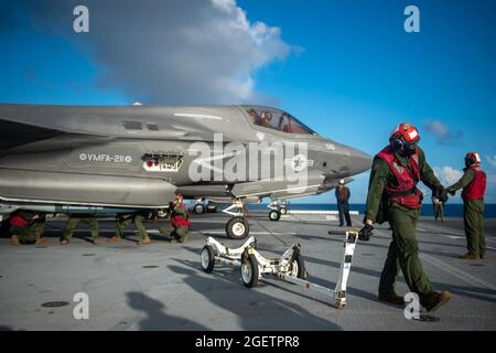 Uss America, Guam. August 2021. US-Marineinfanteristen vom 31. MEU laden inerte Kampftruppen in ein Marine Corps F-35B Lightning II Stealth-Kampfflugzeug, das an Marine Fighter Attack Squadron 211 angeschlossen ist, und bereiten sich darauf vor, während eines Fluges zum Royal Navy-Flugzeugträger HMS Queen Elizabeth vom amphibischen Angriffsschiff USS America abzuheben Einsätze am 20. August 2021 in der philippinischen See. Quelle: Planetpix/Alamy Live News Stockfoto