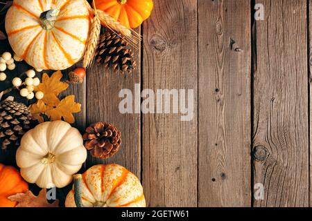 Natürliche Fallseite Rand von Kürbissen und Blättern. Draufsicht auf einem rustikalen dunklen Holzhintergrund mit Kopierfläche. Stockfoto