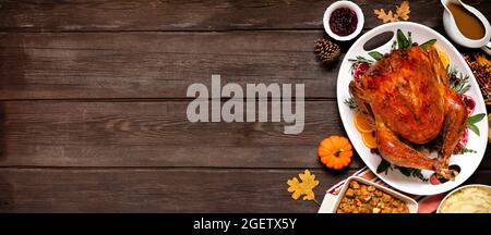 Traditionelles Thanksgiving-truthahn-Abendessen Seitenrand der Deckenansicht auf einem dunklen Holzbanner-Hintergrund mit Kopierfläche. Stockfoto