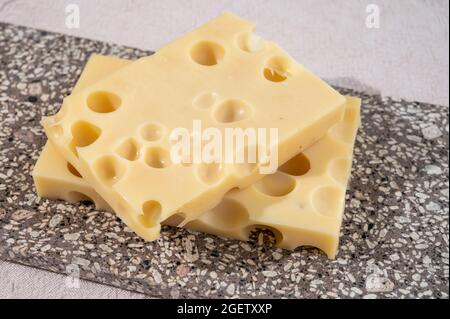 Käsesammlung, halbharter französischer Käse emmentaler mit runden Löchern aus Kuhmilch aus der Nähe Stockfoto