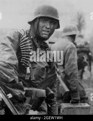 ARDENNEN, BELGIEN - 1944. Dezember - EIN Geman-Soldat, schwer bewaffnet, trägt Munitionskisten mit seinem Gefährten auf dem von ihren Grafinnen und Grafinnen entnommenen Gebiet nach vorne Stockfoto