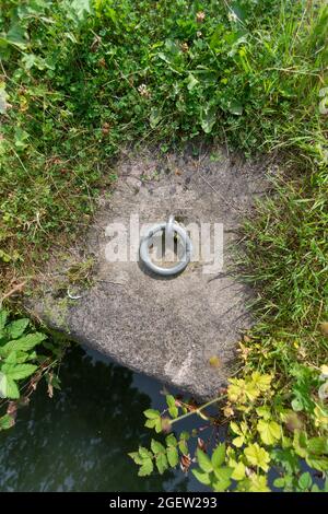 Ein Anlegering, der am Betonboden an der Seite des Cromford Canal in Derbyshire befestigt ist Stockfoto