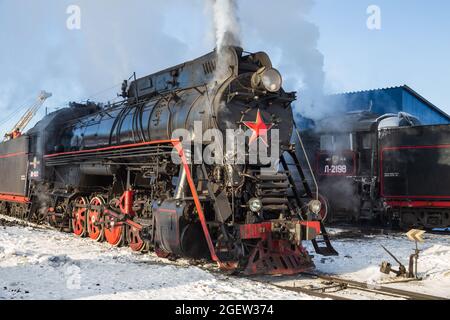 SORTAVALA, RUSSLAND - 10. MÄRZ 2021: Alte Dampflokomotive pumpt weiße Rauchwolken am Bahnhof von Sortavala aus Stockfoto