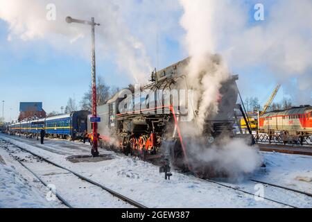 SORTAVALA, RUSSLAND - 10. MÄRZ 2021: Touristischer Retrozug Ruskeala Express mit Dampflokomotive brennt zur Abfahrt von der Sortavala-Eisenbahnlinie Stockfoto