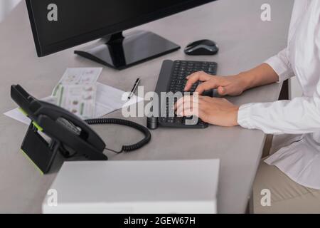 Beschnittene Ansicht des Arbeitsplatzes einer Arbeiterin im Büro Stockfoto