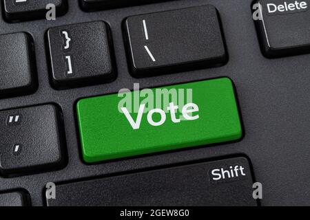 Abstimmtaste auf einer schwarzen pc-Tastatur. Online-Wahlbeteiligung, Internet-Voting und E-Voting-Konzepte. Computer Notebook Schlüssel mit Abstimmwort eingeben. Stockfoto