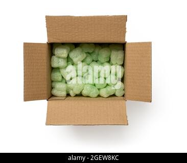 Verpackung Schaumstofffüller im Karton isoliert auf weißem Hintergrund. Offene braune Box gefüllt mit grünen losen Füllern zum Schutz empfindlicher Pakete. Stockfoto