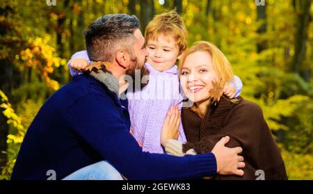 Mutter, Vater und Sohn auf Herbstspaziergang im Park. Frohe Familie. Eltern und Kind entspannen sich gemeinsam an sonnigen Tagen. Stockfoto