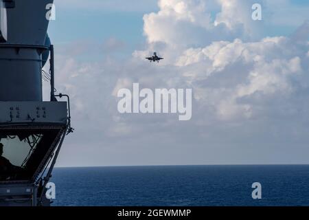 PHILIPPINISCHES MEER (Aug 20, 2021) ein F-35B Lightning II-Kampfflugzeug von VMFA 211, das auf der Royal Navy Aircraft Carrier HMS Queen Elizabeth (R08) gestartet wurde, bereitet sich auf das Flugdeck des nach vorne eingesetzten amphibischen Angriffsschiffes USS America (LHA 6) während des Flugbetriebs zwischen der Queen Elizabeth und Amerika vor. Amerika, das Flaggschiff der America Expeditionary Strike Group, und die 31. Marine Expeditionary Unit sind im Verantwortungsbereich der 7. Flotte der USA tätig, um die Interoperabilität mit Verbündeten und Partnern zu verbessern und als einsatzbereite Einsatztruppe zur Verteidigung von pe zu dienen Stockfoto