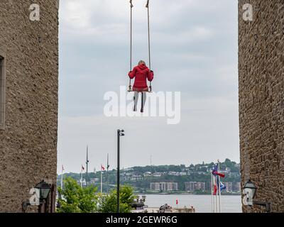 Quebec City, Kanada - Juli 21 2021: Street Art Stück eines Mädchens, das auf Schaukel in der Innenstadt von Quebec City sitzt Stockfoto