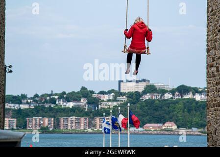 Quebec City, Kanada - Juli 21 2021: Street Art Stück eines Mädchens, das auf Schaukel in der Innenstadt von Quebec City sitzt Stockfoto