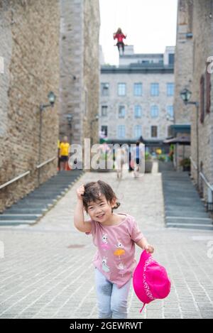 Quebec City, Kanada - Juli 21 2021: Kleines Mädchen mit rotem Hut spielt in der Innenstadt von Quebec City Stockfoto