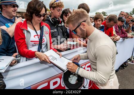 Rennfahrer Sam Bird signiert Autogramme beim Goodwood Festival of Speed Rennsport Event 2014. Rennfahrer mit Rennfans. Autogrammjäger Stockfoto