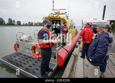 Richmond, Kanada. August 2021. Ein Mitglied der Royal Canadian Marine Search and Rescue erklärt Besuchern seine Arbeit während des 18. Jährlichen Maritime Festivals in Richmond, British Columbia, Kanada, am 21. August 2021. Das 18. Jährliche Richmond Maritime Festival, das vom 21. Bis 22. August stattfindet, zeigt das kulturelle und maritime Erbe mit historischen Artefakten, maritimen Ausstellungen und Aufführungen. Quelle: Liang Sen/Xinhua/Alamy Live News Stockfoto