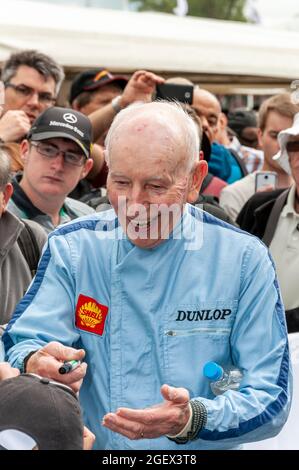 John Surtees signiert Autogramme beim Goodwood Festival of Speed. Legendärer Formel-1-Grand-Prix-Rennfahrer. Scherz mit einem jungen Fan (außer Schuss) Stockfoto