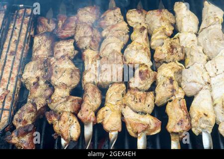 Braten von Fleischspießen über Holzkohle, die auf dem Grill gegrillt werden Stockfoto