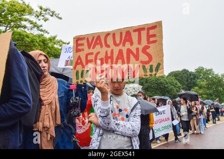 London, Großbritannien. August 2021. Ein junger Protestler hält ein Plakat, auf dem steht, dass die Afghanen jetzt während der Demonstration im Hyde Park evakuiert werden.Demonstranten marschierten durch Central London, um gegen die Übernahme Afghanistans durch die Taliban zu protestieren.Sie forderten die britische Regierung auf, Sanktionen gegen Pakistan zu verhängen und den Menschen in Afghanistan zu helfen. (Foto: Vuk Valcic/SOPA Images/Sipa USA) Quelle: SIPA USA/Alamy Live News Stockfoto