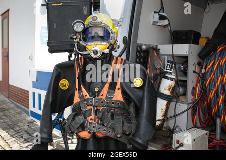 Ein Industrie-Tauchanzug mit Tauchhelm, Luftschlauch und Gewichten. Stockfoto